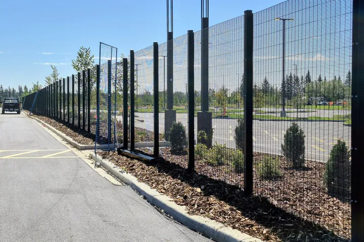 Black welded mesh security fence along a landscaped site in Edmonton