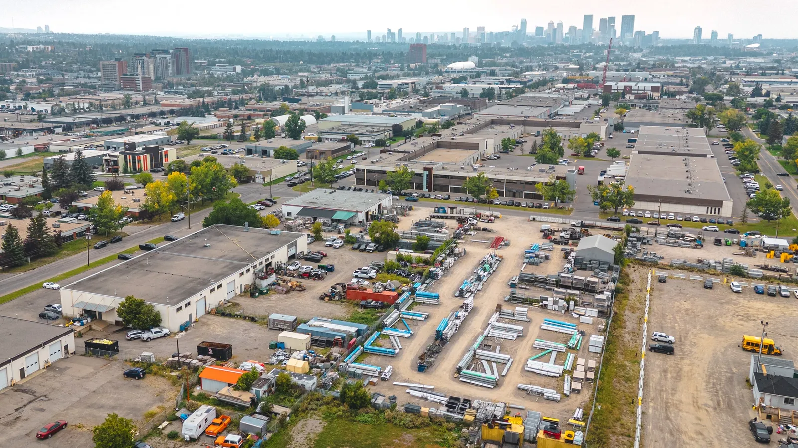 Aerial view of the Phoenix Fence Calgary shop and yard with the downtown skyline beyond