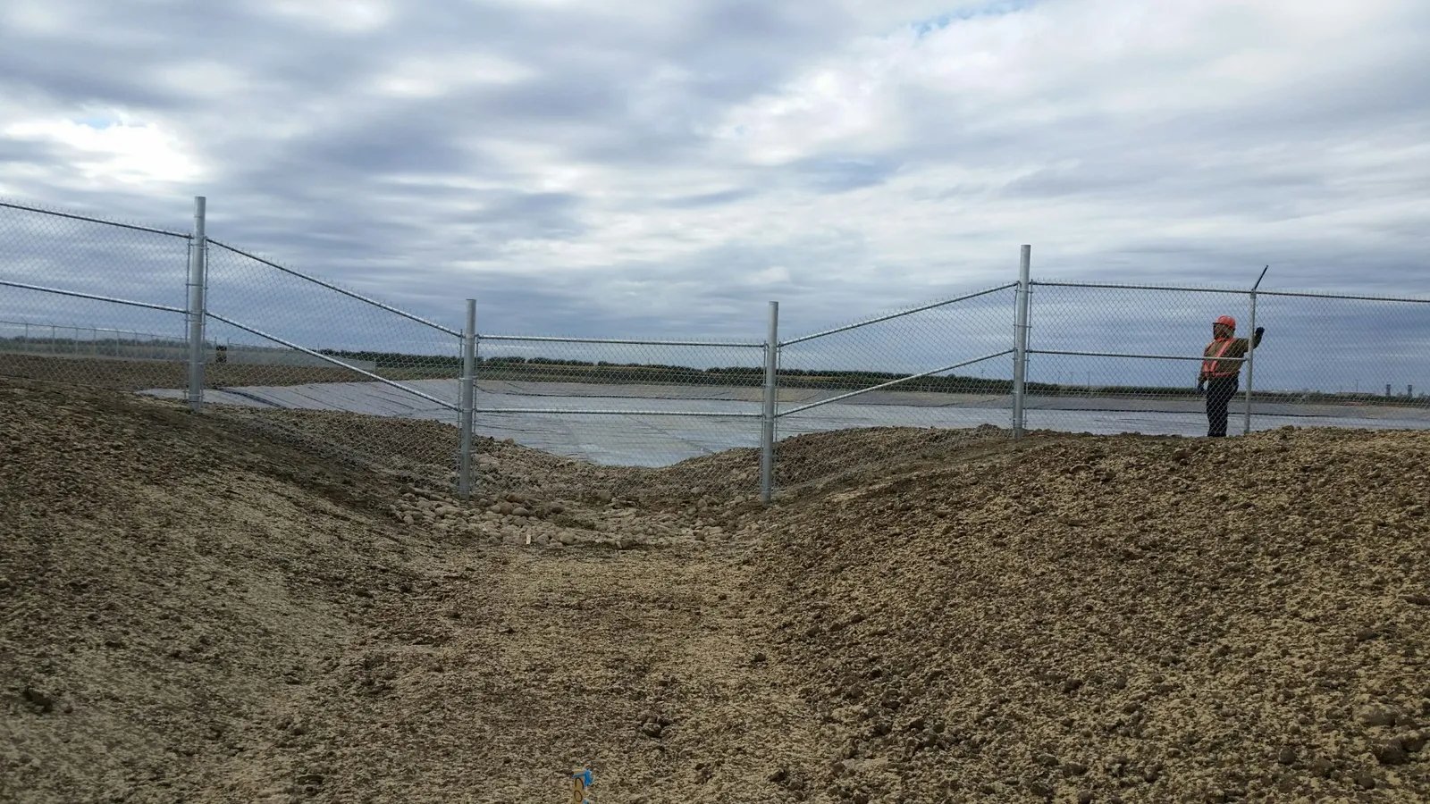 Galvanized chain link fence panels along an industrial site