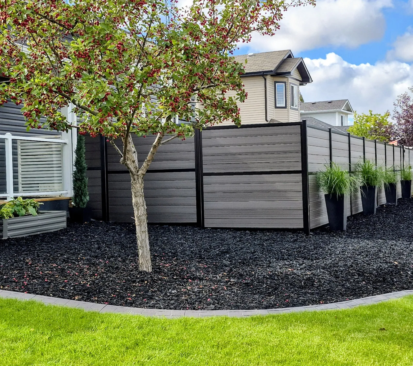 Karbon Premium horizontal board fence in grey with black posts around a residential yard