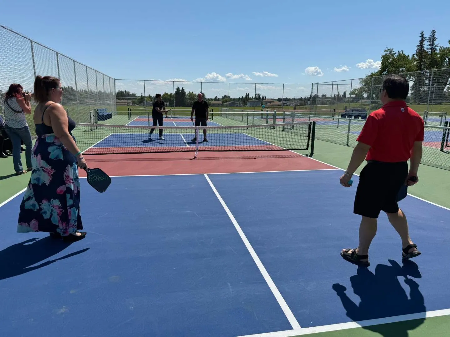Outdoor pickleball courts enclosed with chain link fence