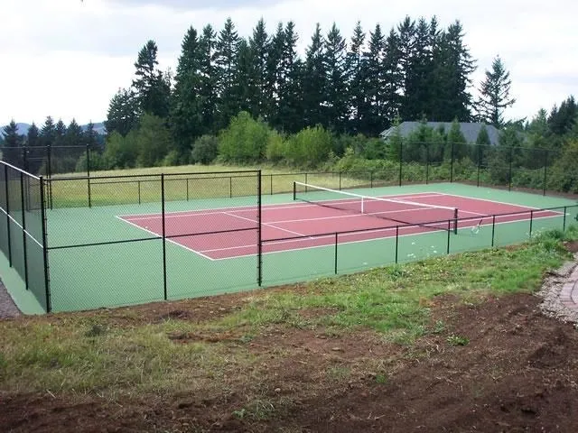 Tennis court enclosed with black chain link fence
