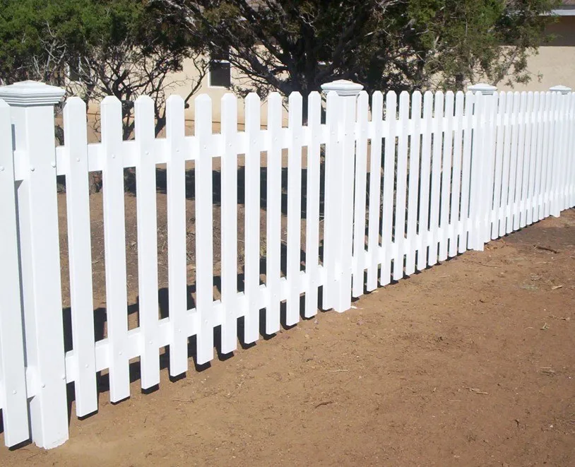White colonial picket vinyl fence along a garden bed